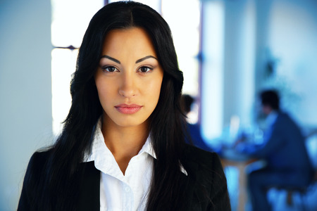 Beautiful woman standing in office with colleagues on backgroundの写真素材