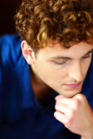 Closeup portrait of a young pensive man with curly hair