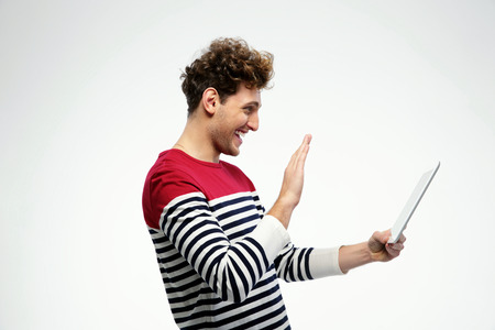 Side view portrait of a young man using tablet computer over gray backgroundの写真素材