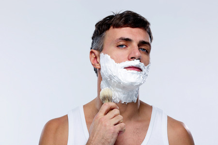 Man preparing to shave, applying shaving foam with a shaving brushの写真素材