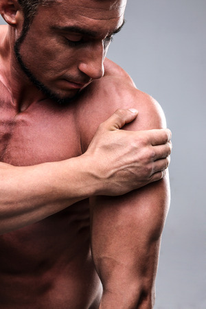 Closeup portrait of a handsome man touching his shoulderの写真素材