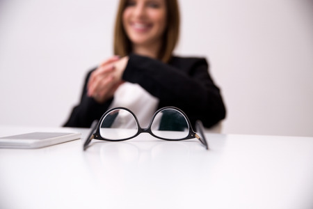 Closeup image of glasses and smartphone on tableの写真素材