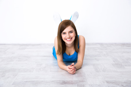 Portrait of attractive happy woman lying on the floorの写真素材