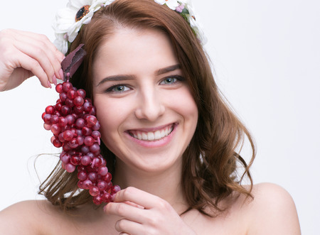 Portrait of a smiling beautiful woman holding currantの写真素材