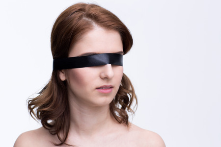 Blindfold beautiful woman over gray backgroundの写真素材