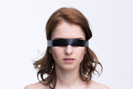 Blindfold young woman over gray backgroundの写真素材