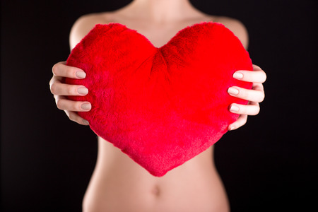 Closeup image of female hands holding red heartの写真素材