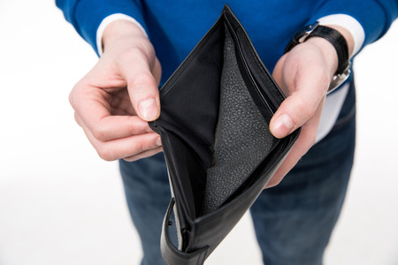Closeup image of a man holding emty wallet over white backgroundの写真素材