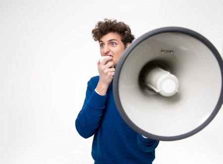 Man shouting through megaphone over gray backgroundの写真素材