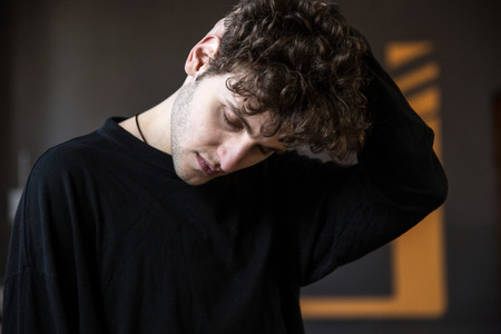 Young man stretching neck at gymの写真素材