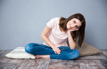 Young cute woman sitting on the floorの写真素材