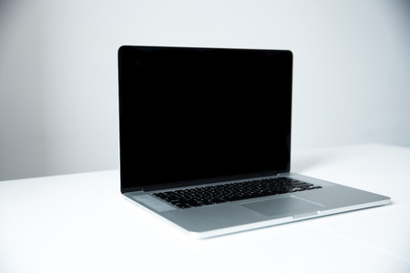 Closeup image of a laptop on the table in office over gray background
