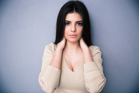 Beautiful young caucasian woman looking at camera. Posing over gray background.の写真素材