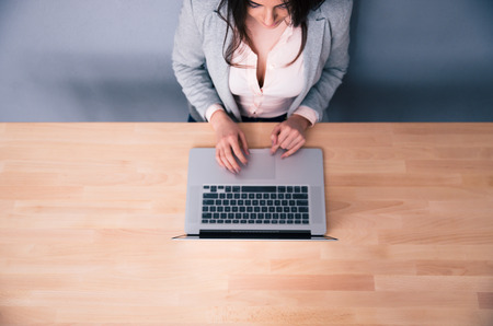 Top view portrait of a woman using laptop on the wooden desk.の写真素材