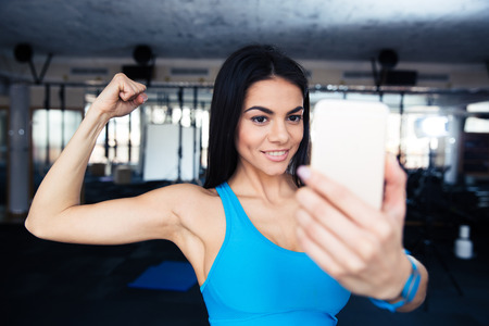 Sports woman making selfie on smartphone at gymの写真素材