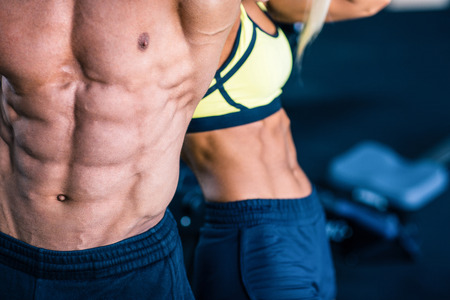 Closeup image of a muscular man's and strong woman's torsoの写真素材