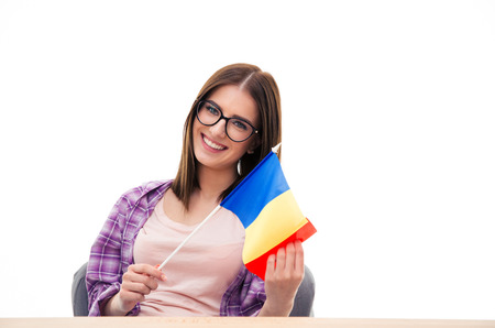 Young woman sitting at the table with french flag over white backgroundの写真素材