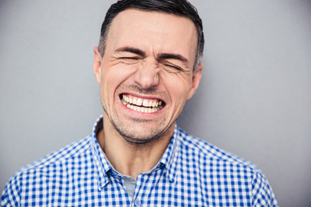 Portrait of a handsome man screaming over gray wallの写真素材
