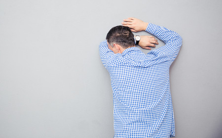 Stressed man leaning on the wallの写真素材