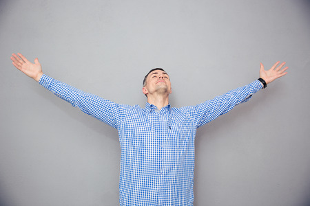 Portrait of a man gesturing freedom expression over gray backgroundの写真素材