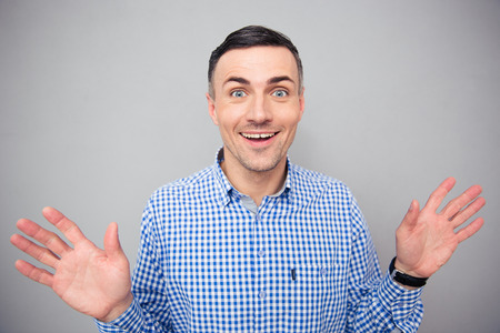 Portrait of a smiling man looking at camera over gray backgroundの写真素材