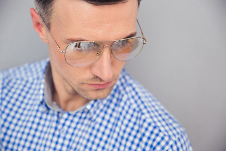 Stylish man in glasses over gray backgroundの写真素材