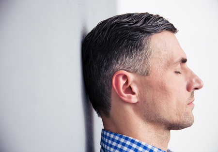 Side view portrait of a relaxed man leaning on the wallの写真素材