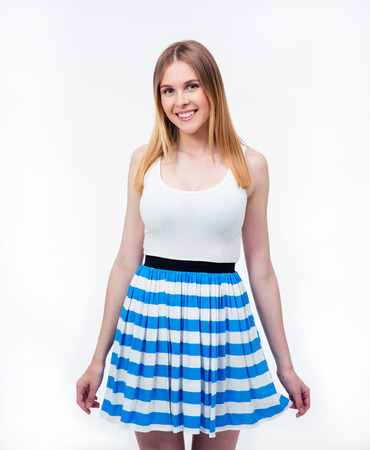 Portrait of a smiling cute woman in dress standing over gray background and looking at cameraの写真素材