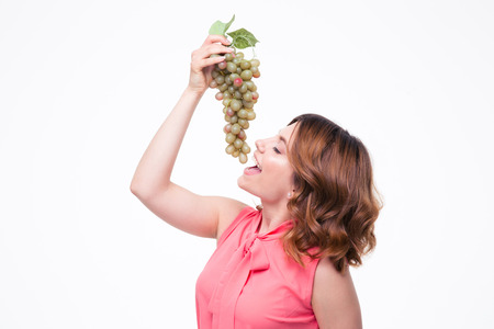 Young cute woman eating grapes isolated on a white backgroundの写真素材