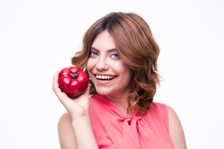 Smiling attractive woman holding tomato isolated on a white background. Looking at cameraの写真素材
