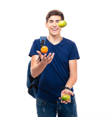 Casual young man juggles with fruits isolated on a white backgroundの写真素材