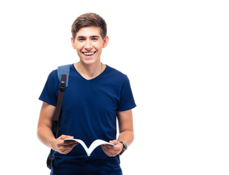 Happy male student standing and holding book isolated on a white background. Looking at cameraの写真素材