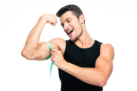 Happy fitness man measuring his biceps isolated on a white background