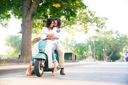 Happy european couple flirting on scooter in the townの写真素材