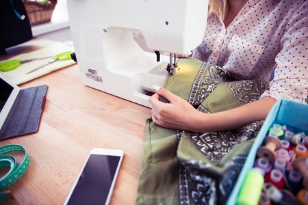 Closeup portrait of a woman using a sewing machineの写真素材