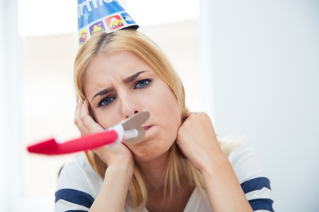 Beautiful woman with party hat and blows whistleの写真素材