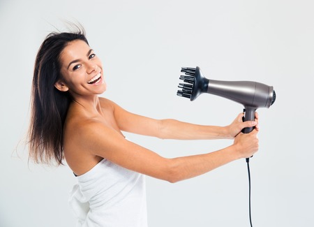 Laughing woman in towel drying her hair isolated on a white backgroundの写真素材