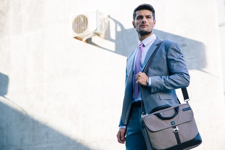 Portrait of a confident businessman standing outdoors near office building
