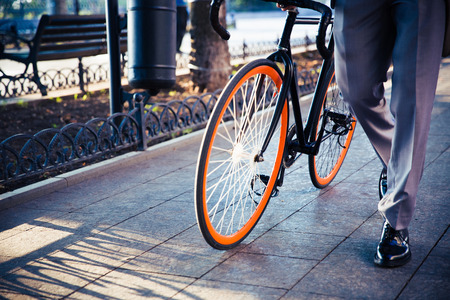 Closeup portrait of a businessman walking with bicycle