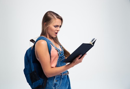Shocked young woman reading book isolated on a white background