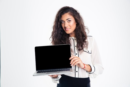 Portrait of a smiling businesswoman showing blank laptop computer screen isolated on a white backgroundの写真素材