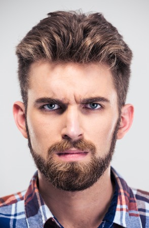Closeup portrait of a serious man looking at camera isolated on a white backgroundの写真素材
