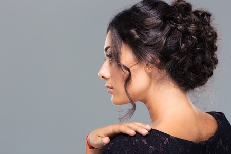 Beauty portrait of a pretty woman looking away over gray background