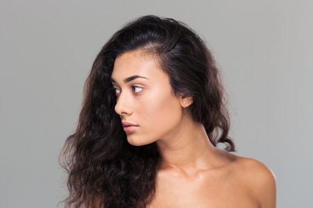 Beauty portrait of a pretty woman looking away over gray backgroundの写真素材