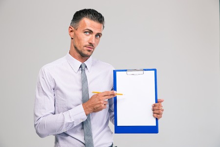 Portrait of a handsome businessman showing blank clipboard isolated on a white backgroundの写真素材