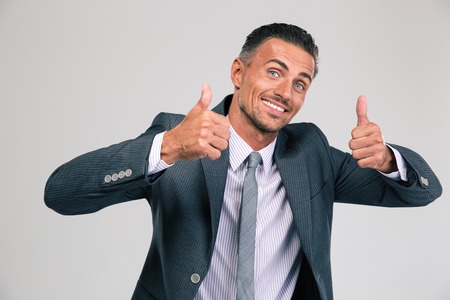 Portrait of a funny man showing thumbs up isolated on a white background. Looking at cameraの写真素材