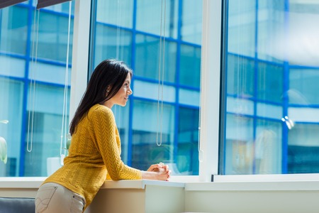 Portrait of a casual businesswoman looking at window in officeの写真素材