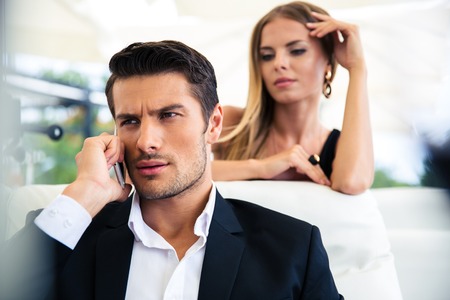 Confident businessman talking on the phone in restaurantの写真素材