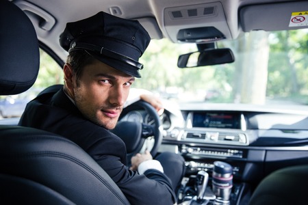 Portrait of a handsome male chauffeur sitting in a carの写真素材