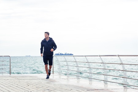 Portrait of a man running near sea outdoorsの写真素材